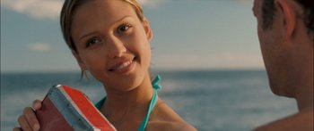 Movie still from “Into the Blue” (2005), directed by John Stockwell – A beautiful young lady holding a surfboard in front of the ocean; Close Up shot, Low angle