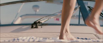 Movie still from “Into the Blue” (2005), directed by John Stockwell – A person standing on a towel near a swimming pool; Extreme Close Up shot, Low angle