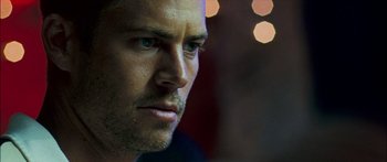 Movie still from “Into the Blue” (2005), directed by John Stockwell – A man's face in front of lights; Close Up shot, Over the shoulder angle