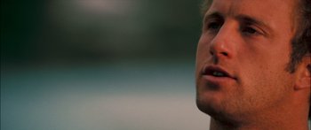 Movie still from “Into the Blue” (2005), directed by John Stockwell – A man's face with a blurry background; Close Up shot, Low angle