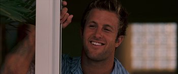 Movie still from “Into the Blue” (2005), directed by John Stockwell – A person smiling near a window; Close Up shot, Over the shoulder angle