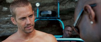 Movie still from “Into the Blue” (2005), directed by John Stockwell – A person in a gym; Close Up shot, Over the shoulder angle