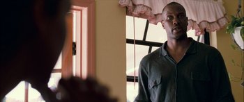 Movie still from “Into the Blue” (2005), directed by John Stockwell – A man standing in front of a window in a room; Medium shot, Over the shoulder angle