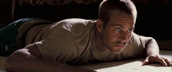 Movie still from “Into the Blue” (2005), directed by John Stockwell – A person laying on the ground; Close Up shot, Overhead angle