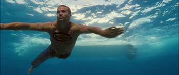 Movie still from “Into the Blue” (2005), directed by John Stockwell – A man swimming in a body of water; Medium shot, High angle