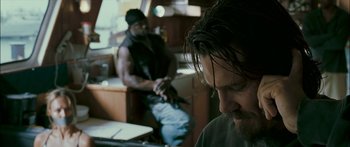 Movie still from “Into the Blue” (2005), directed by John Stockwell – A man sitting in front of another man holding a gun; Close Up shot, Over the shoulder angle
