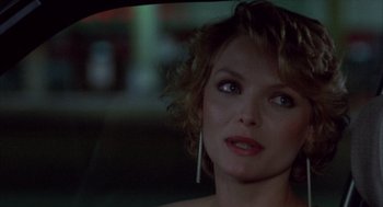 Movie still from “Into the Night” (1985), directed by John Landis – A person in a car; Close Up shot, Over the shoulder angle