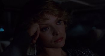 Movie still from “Into the Night” (1985), directed by John Landis – A person holding a pen in their hand; Close Up shot, Low angle