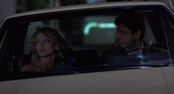 Movie still from “Into the Night” (1985), directed by John Landis – A man and a woman sitting in the back of a car; Medium shot, Low angle