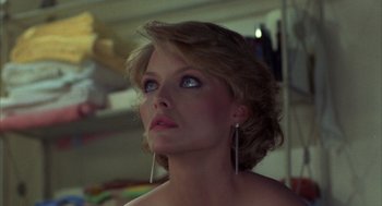 Movie still from “Into the Night” (1985), directed by John Landis – A woman with long blonde hair and blue eyes looking up; Close Up shot, Low angle