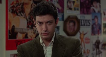 Movie still from “Into the Night” (1985), directed by John Landis – A person wearing a suit and tie; Close Up shot, Over the shoulder angle