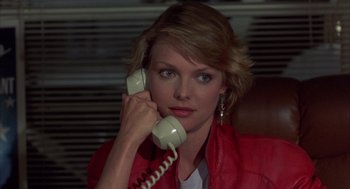 Movie still from “Into the Night” (1985), directed by John Landis – A woman holding a phone up to her ear; Close Up shot, Low angle