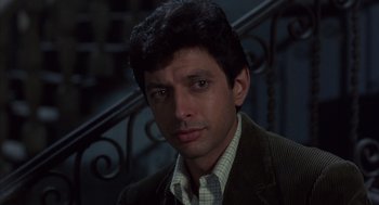 Movie still from “Into the Night” (1985), directed by John Landis – A person wearing a suit and tie; Close Up shot, Low angle