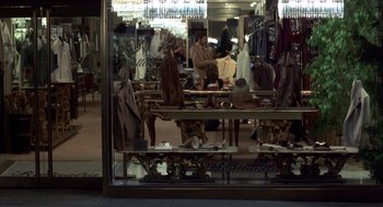 Movie still from “Into the Night” (1985), directed by John Landis – A store front with a lot of clothes on the tables; Wide shot, High angle