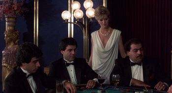 Movie still from “Into the Night” (1985), directed by John Landis – A man and a woman sitting at a poker table; Medium shot, Low angle