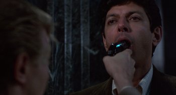 Movie still from “Into the Night” (1985), directed by John Landis – A man is brushing his teeth with an electric toothbrush; Close Up shot, Over the shoulder angle