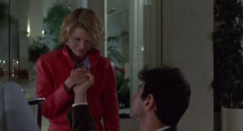 Movie still from “Into the Night” (1985), directed by John Landis – A man and a woman holding hands in a room; Medium shot, Over the shoulder angle