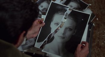 Movie still from “Into the Night” (1985), directed by John Landis – A person holding up a picture of a woman's face; Extreme Close Up shot, Overhead angle