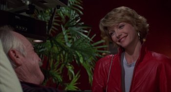 Movie still from “Into the Night” (1985), directed by John Landis – A woman in a red jacket talking to a man; Medium shot, Over the shoulder angle
