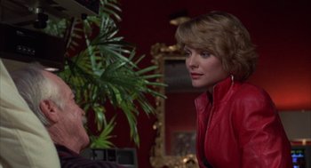Movie still from “Into the Night” (1985), directed by John Landis – A woman wearing a red jacket talking to a man; Medium shot, Over the shoulder angle