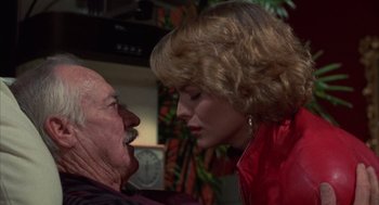 Movie still from “Into the Night” (1985), directed by John Landis – An older man and a young woman are kissing; Close Up shot, Over the shoulder angle