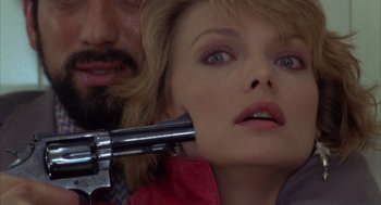 Movie still from “Into the Night” (1985), directed by John Landis – A man and a woman with a gun in their hands; Close Up shot, Overhead angle