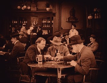 Movie still from “Intolerance” (1916), directed by D.W. Griffith – A group of men sitting at a table playing cards; Wide shot, High angle