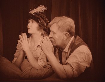 Movie still from “Intolerance” (1916), directed by D.W. Griffith – An old photo of a man and a woman praying; Medium shot, High angle