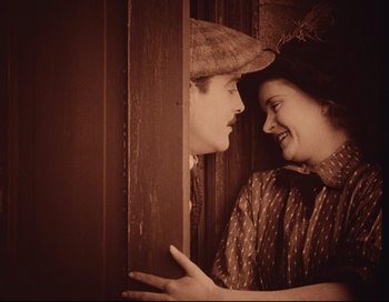 Movie still from “Intolerance” (1916), directed by D.W. Griffith – An old photo of a man and a woman looking at each other; Medium shot, High angle