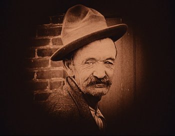 Movie still from “Intolerance” (1916), directed by D.W. Griffith – An old man wearing a hat and a jacket; Close Up shot, High angle