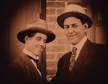 Movie still from “Intolerance” (1916), directed by D.W. Griffith – A couple of men standing next to each other; Close Up shot, Low angle