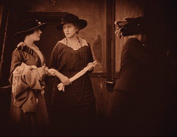 Movie still from “Intolerance” (1916), directed by D.W. Griffith – A group of women standing next to each other in a room; Medium shot, Low angle