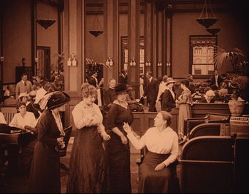 Movie still from “Intolerance” (1916), directed by D.W. Griffith – A group of people standing in a room; Wide shot, High angle