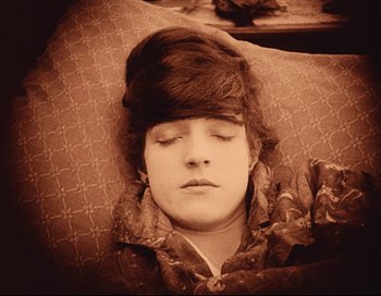 Movie still from “Intolerance” (1916), directed by D.W. Griffith – A young man sleeping on a couch with his eyes closed; Close Up shot, High angle