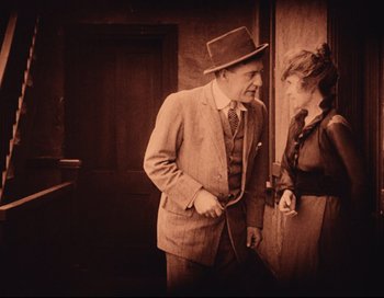 Movie still from “Intolerance” (1916), directed by D.W. Griffith – An old photo of a man and a woman standing next to each other; Medium shot, High angle