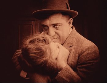 Movie still from “Intolerance” (1916), directed by D.W. Griffith – An older man holding a young girl in his arms; Extreme Close Up shot, High angle