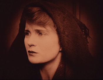 Movie still from “Intolerance” (1916), directed by D.W. Griffith – An old photo of a woman wearing a hood; Close Up shot, High angle