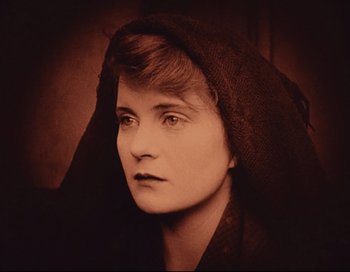 Movie still from “Intolerance” (1916), directed by D.W. Griffith – An old photo of a woman wearing a hood; Close Up shot, Low angle