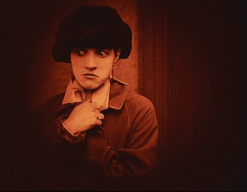 Movie still from “Intolerance” (1916), directed by D.W. Griffith – A young man wearing a black hat and a jacket; Close Up shot, High angle