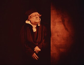 Movie still from “Intolerance” (1916), directed by D.W. Griffith – An old man wearing a hat and a gown; Medium shot, Low angle