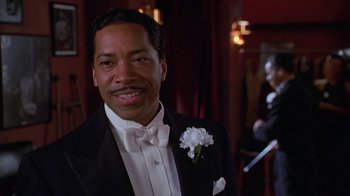 Movie still from “Introducing Dorothy Dandridge” (1999), directed by Martha Coolidge – A man in a tuxedo smiling for the camera; Close Up shot, Low angle