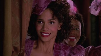 Movie still from “Introducing Dorothy Dandridge” (1999), directed by Martha Coolidge – A woman in a purple dress smiling for the camera; Close Up shot, Over the shoulder angle