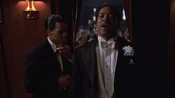 Movie still from “Introducing Dorothy Dandridge” (1999), directed by Martha Coolidge – Two men in tuxedos stand next to each other in front of an audience; Medium shot, Low angle