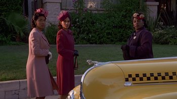 A group of women standing in front of a yellow taxi cab