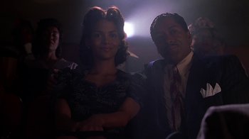 Movie still from “Introducing Dorothy Dandridge” (1999), directed by Martha Coolidge – A man and a woman posing for a picture in a dark room; Medium shot, Low angle