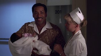Movie still from “Introducing Dorothy Dandridge” (1999), directed by Martha Coolidge – A man and a woman holding a newborn baby; Medium shot, Over the shoulder angle