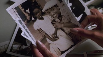 Movie still from “Introducing Dorothy Dandridge” (1999), directed by Martha Coolidge – A person holding an old photo of a man and a woman; Close Up shot, High angle