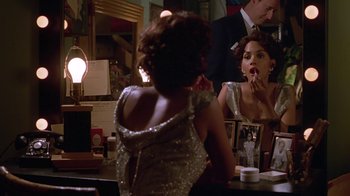 Movie still from “Introducing Dorothy Dandridge” (1999), directed by Martha Coolidge – A woman is sitting at a table in front of a mirror; Medium shot, Over the shoulder angle