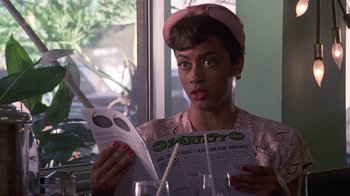Movie still from “Introducing Dorothy Dandridge” (1999), directed by Martha Coolidge – A woman sitting at a table reading a newspaper; Close Up shot, High angle