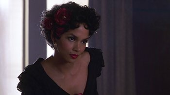 Movie still from “Introducing Dorothy Dandridge” (1999), directed by Martha Coolidge – A woman in a black dress with red flowers in her hair; Close Up shot, Over the shoulder angle